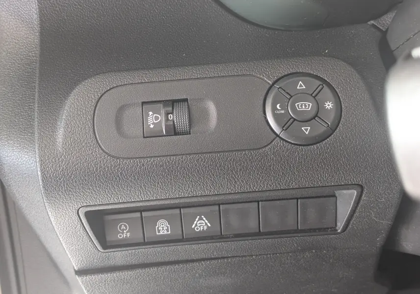 Détail des commandes de réglage des rétroviseurs et des aides à la conduite sur tableau de bord noir du Citroën Berlingo beige.