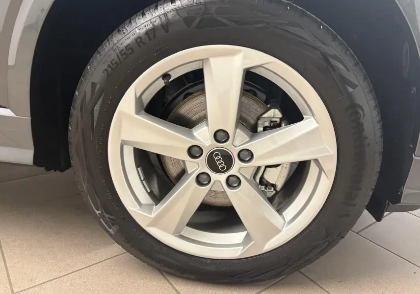 Gros plan sur la roue avant gauche de l'Audi Q2 35 TFSI 150 S Line gris Daytona avec jante alliage cinq branches.