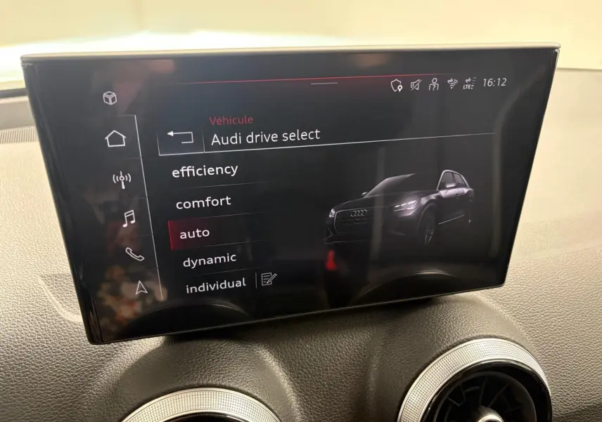 Écran central intérieur affichant le menu Audi drive select avec une image numérique du SUV Audi Q2 en vue 3/4 avant.
