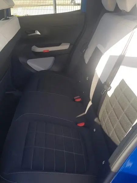 Vue intérieure côté droit des sièges arrière noirs de la Citroën C3 bleu foncé 2024, avec ceinture de sécurité visible.