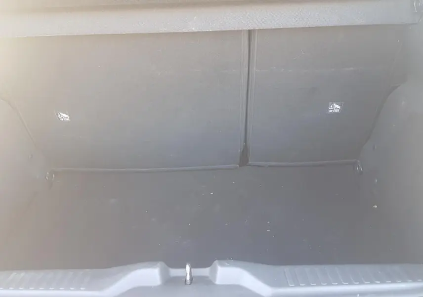 Coffre ouvert vu de face d'une Citroën C3 2024 bleu foncé, montrant l'espace de chargement vide.