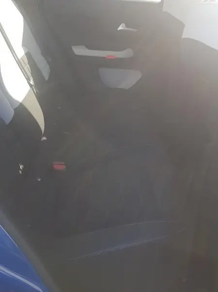 Vue intérieure arrière côté gauche de la Citroën C3 bleu foncé 2024, montrant la banquette et la portière avec accoudoir clair.