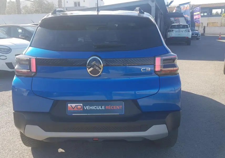 Vue arrière d'une Citroën C3 bleu foncé 2024 avec barres de toit et feux arrière à LED distinctifs.