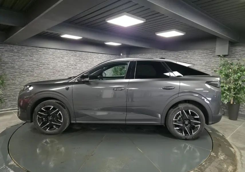 Peugeot 3008 gris métallisé vue de profil côté gauche, avec jantes alliage noires et toit noir contrasté.