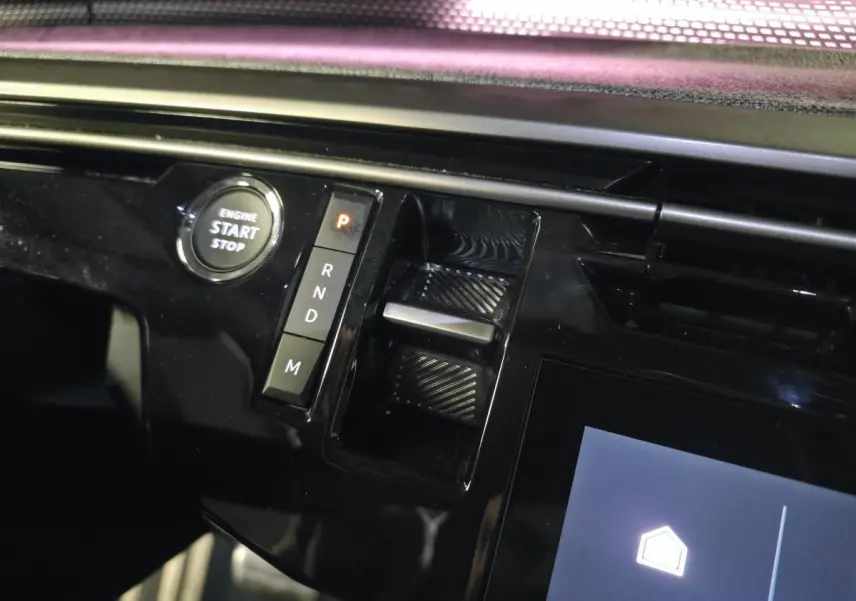 Détail de la console centrale noire brillante du Peugeot 3008 2025 avec bouton start/stop et commandes de boîte auto.