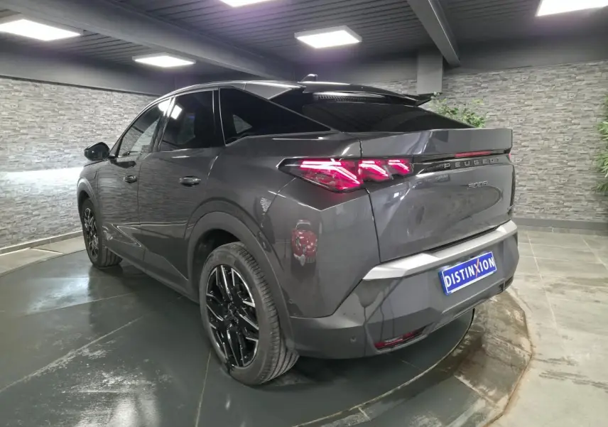 Vue 3/4 arrière droite du Peugeot 3008 gris métallisé 2025 avec feux arrière LED et jantes alliage noires.