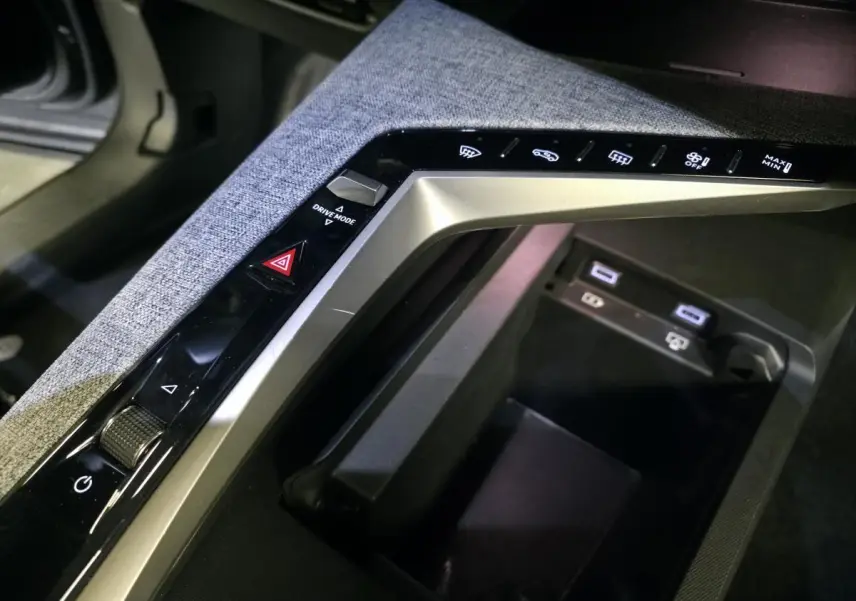 Gros plan sur la console centrale grise chinée du Peugeot 3008 2025 avec commandes tactiles et ports USB-C.
