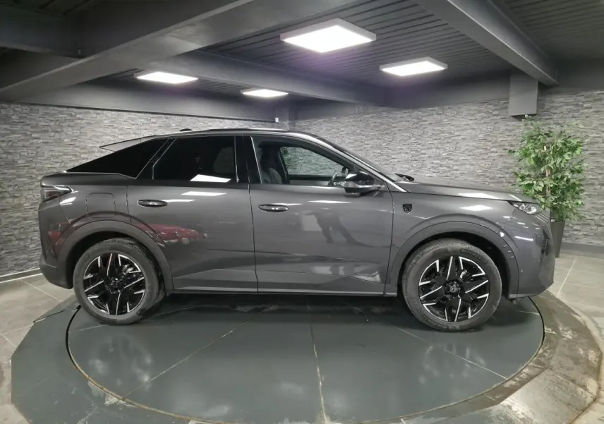 Vue de profil côté gauche du Peugeot 3008 gris 2025 avec toit noir et jantes alliage noires diamantées.