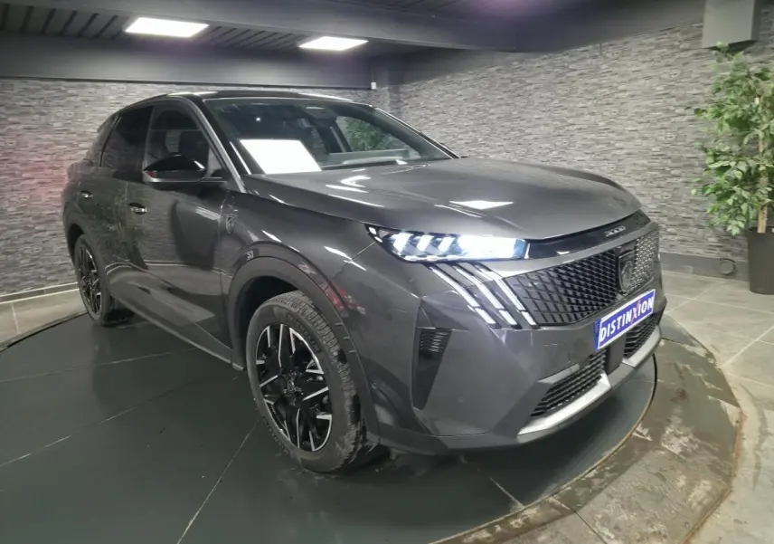 Peugeot 3008 gris métallisé vue 3/4 avant droit, avec phares LED allumés et jantes alliage noires.