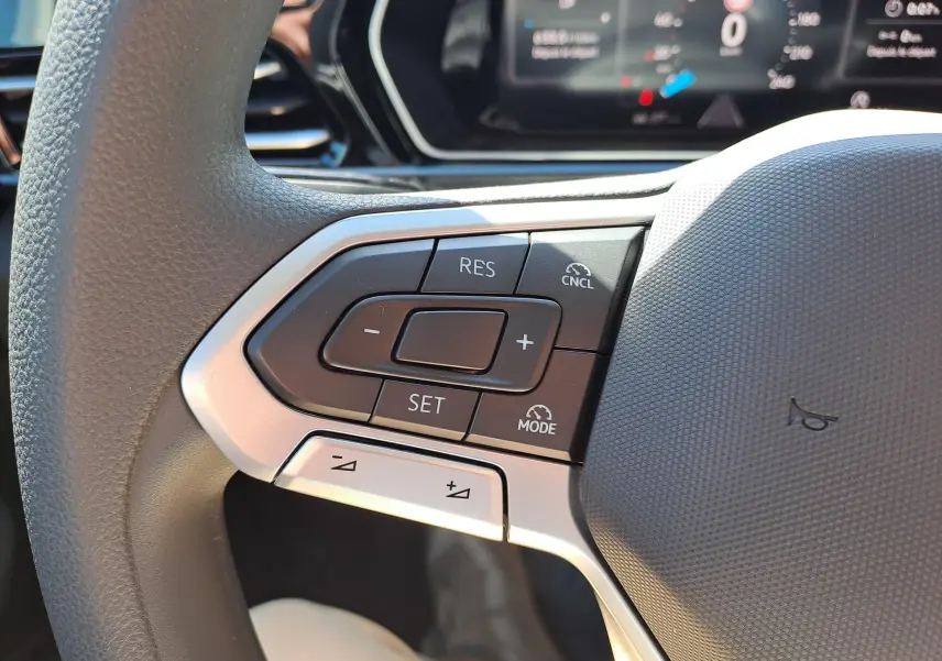 Gros plan sur les commandes au volant côté gauche du Volkswagen Caddy Cargo Maxi 2026, avec boutons de régulateur de vitesse.