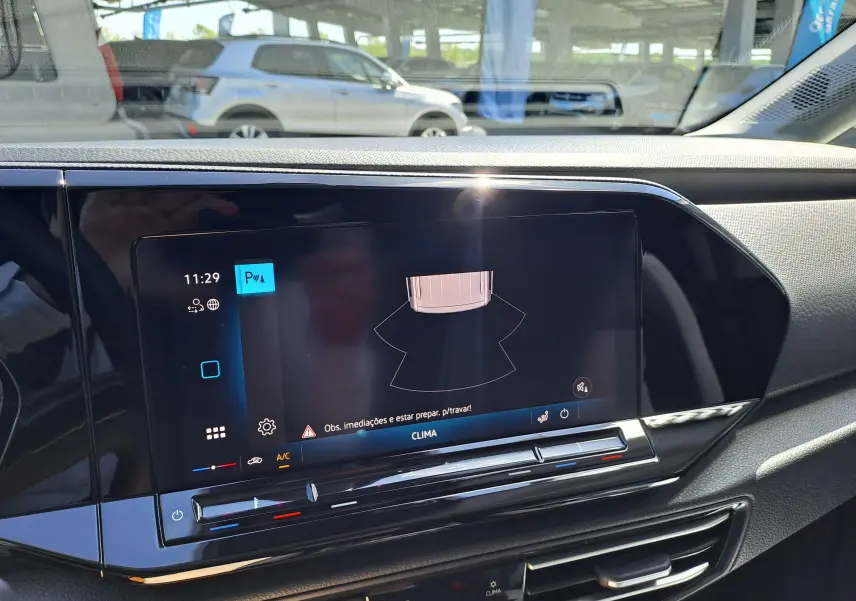 Vue intérieure du tableau de bord du Volkswagen Caddy Cargo Maxi blanc, avec écran tactile central et commandes climatisation visibles.