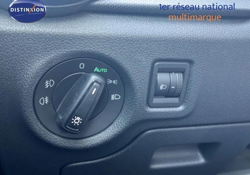 Gros plan sur la molette de réglage des phares dans l'habitacle d'une Skoda Fabia blanche 2022.