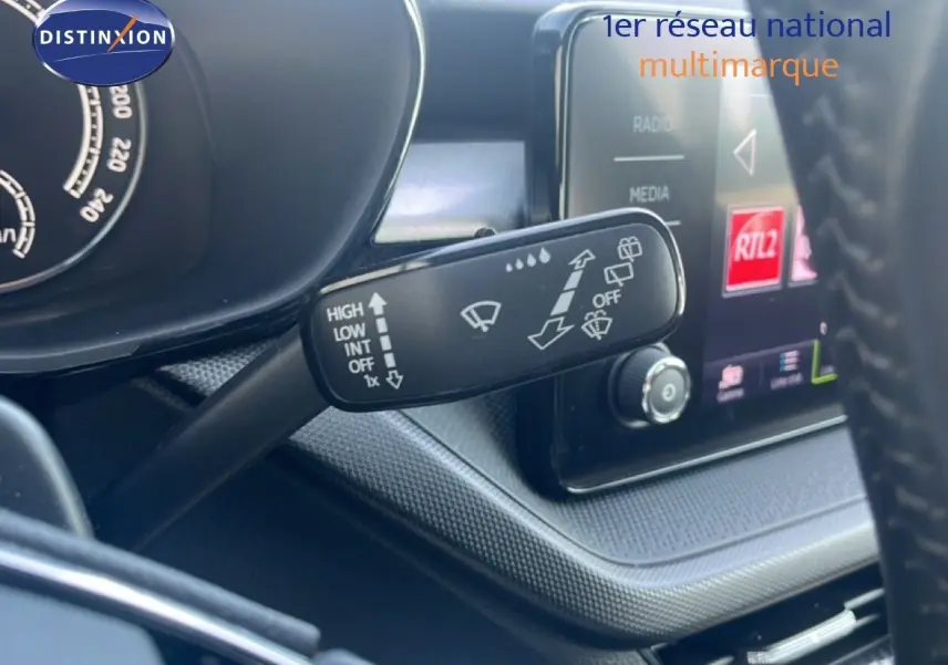 Gros plan sur la commande d’essuie-glace à gauche du volant dans l’habitacle d’une Skoda Fabia blanc candy 2022.
