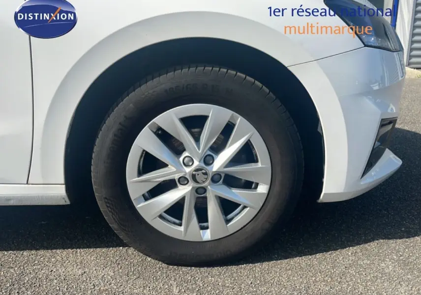 Gros plan sur la roue avant gauche d'une Skoda Fabia blanche Candy avec jante alliage 15 pouces.