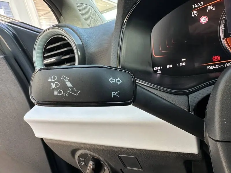 Gros plan sur la commande des clignotants à gauche du volant dans l’habitacle gris clair du SEAT Ibiza 2025.