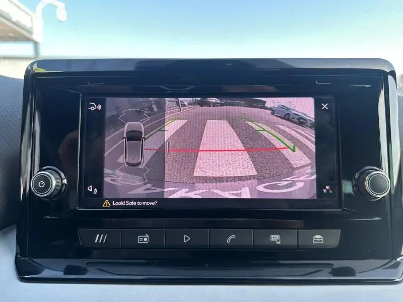 Écran central montrant la caméra de recul avec vue arrière et lignes de guidage sur un SEAT Ibiza gris métallisé.