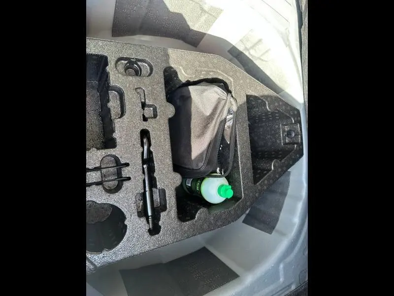 Rangement en mousse dans le coffre de la SEAT Ibiza 2025, contenant une trousse noire et une bouteille verte.