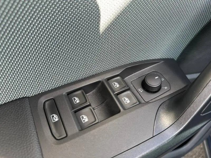 Gros plan sur les commandes des vitres et rétroviseurs côté conducteur de la SEAT Ibiza 2025 en Gris Magnétique Métallisée.