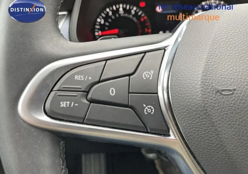 Gros plan sur les commandes de régulateur de vitesse à gauche du volant d’un Renault Arkana noir 2023.