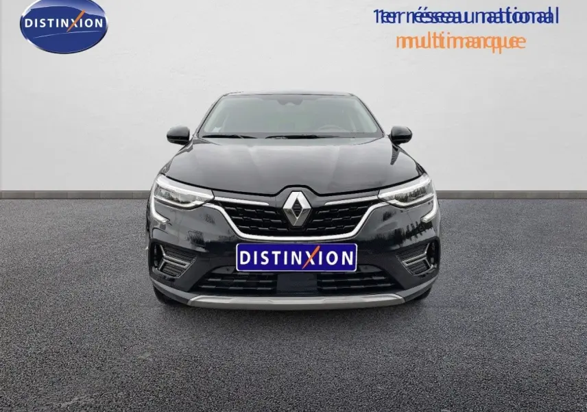 Vue frontale d'une Renault Arkana noire 2023 avec calandre chromée et phares LED allumés sur fond neutre.