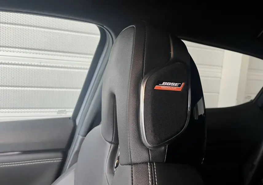 Gros plan sur l’appuie-tête en cuir noir avec haut-parleur Bose intégré dans un Nissan Juke Hybrid 2024.