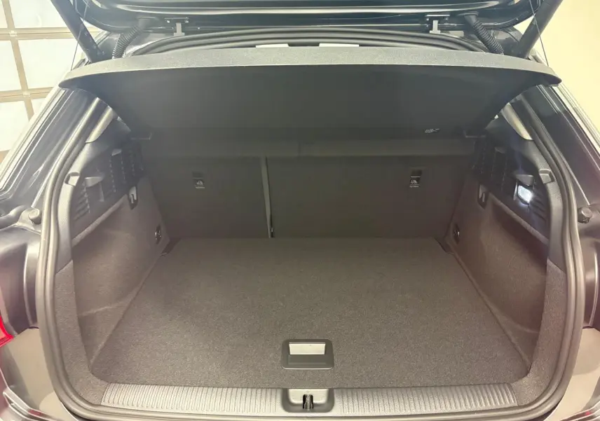 Coffre ouvert vu de l'arrière d'un Audi Q2 35 TFSI S Line gris Daytona avec habillage intérieur noir.