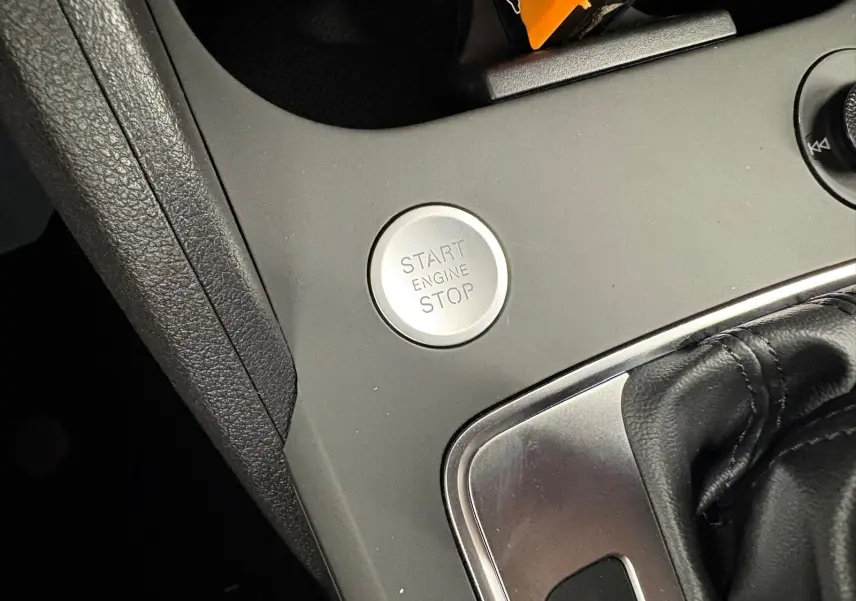 Bouton start/stop moteur en gros plan sur la console centrale d'un Audi Q2 35 TFSI 150 S tronic 7 S line.