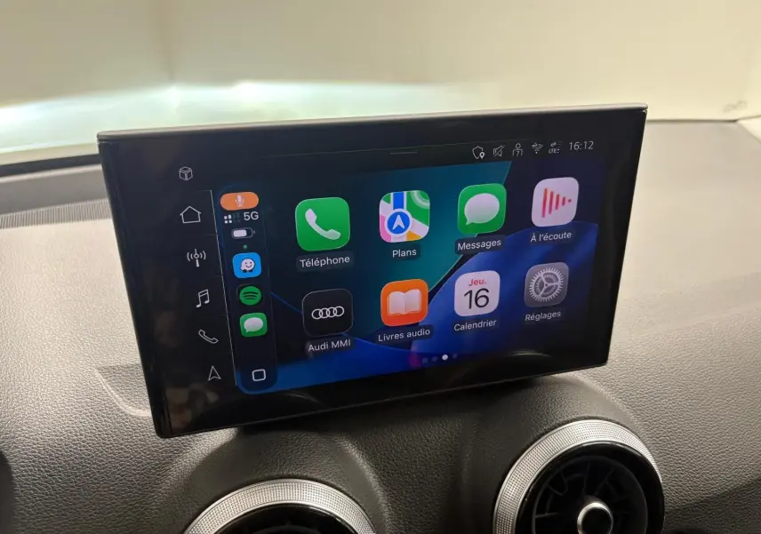 Écran tactile central de l’Audi Q2 35 TFSI S Line 2026 affichant l’interface Apple CarPlay sur tableau de bord noir.