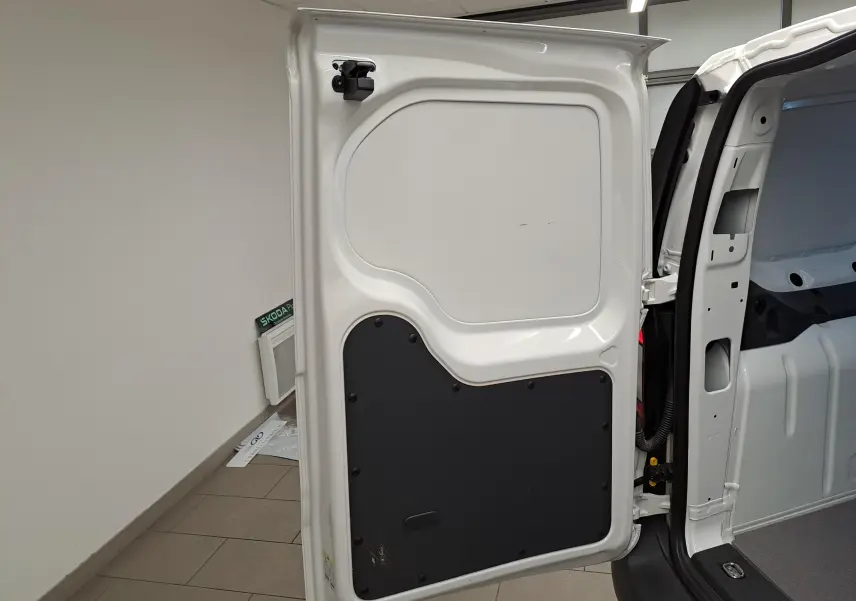 Vue intérieure de la porte arrière droite blanche du Volkswagen Caddy 2025 avec panneau de protection noir.