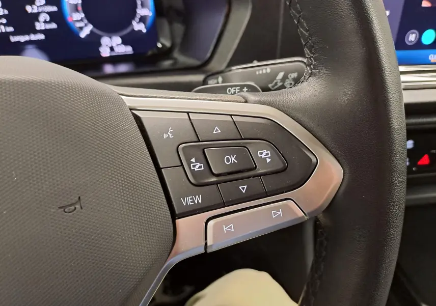 Gros plan sur les commandes multifonctions en cuir noir du volant du Volkswagen Caddy 2025.