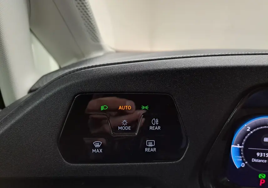 Détail du tableau de bord du Volkswagen Caddy 2025 montrant les commandes d’éclairage automatiques et de désembuage.