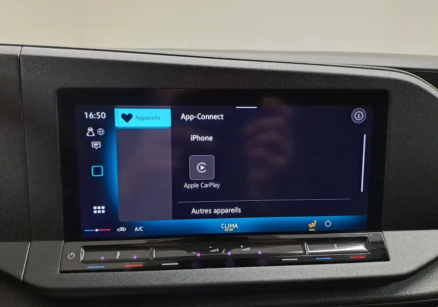 Écran tactile central du Volkswagen Caddy 2025 affichant la fonction App-Connect avec Apple CarPlay, entouré de commandes noires.