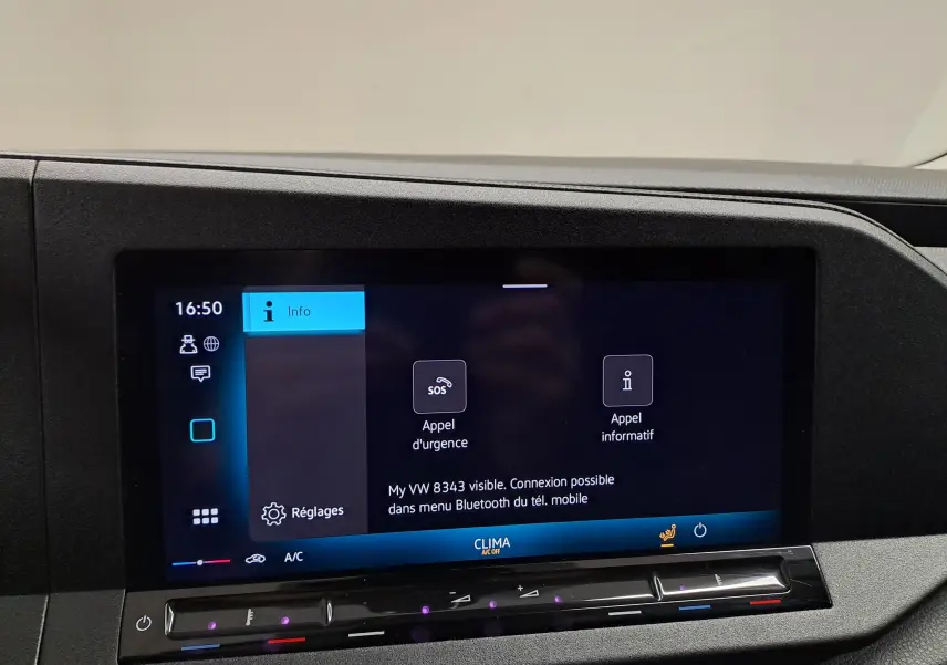 Écran tactile central du tableau de bord du Volkswagen Caddy blanc, affichant les options d'appel d'urgence et réglages.