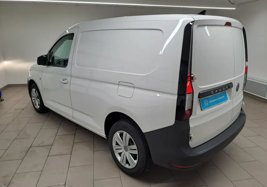 Vue 3/4 arrière droite du Volkswagen Caddy blanc Candy avec pare-chocs noir et jantes acier 16 pouces.