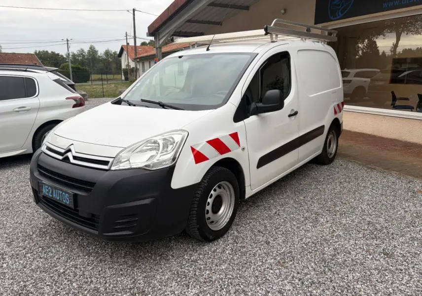 Vue 3/4 avant droit d'un Citroën Berlingo blanc fourgon 2018 avec bandes réfléchissantes rouges sur ailes et galerie de toit.