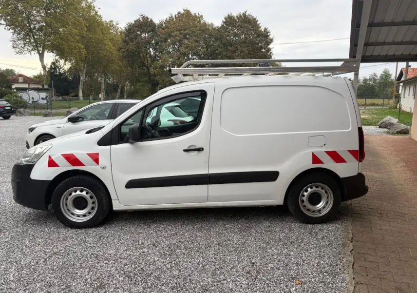 Vue de profil côté gauche d’un Citroën Berlingo blanc fourgon 2018 avec bandes rouges réfléchissantes et galerie sur le toit.