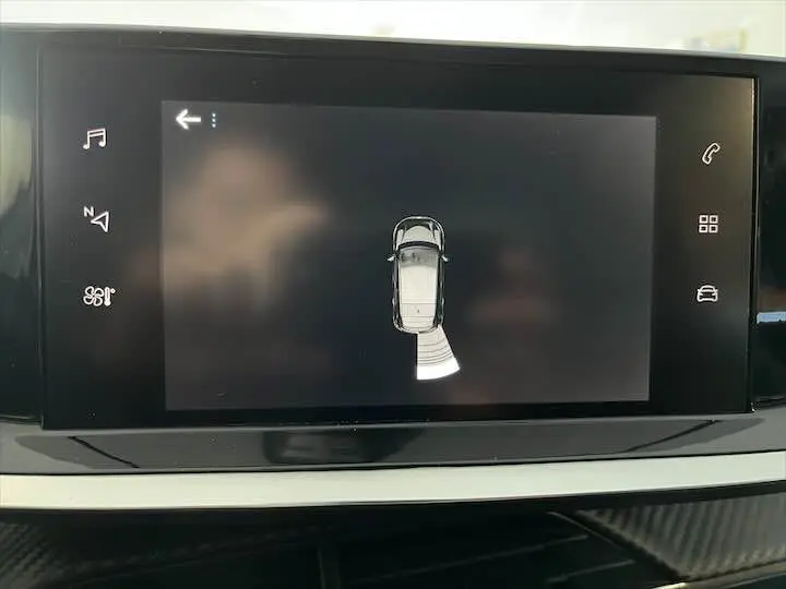 Écran tactile intérieur affichant la vue de dessus du système d'aide au stationnement de la Peugeot 208 gris Artense.