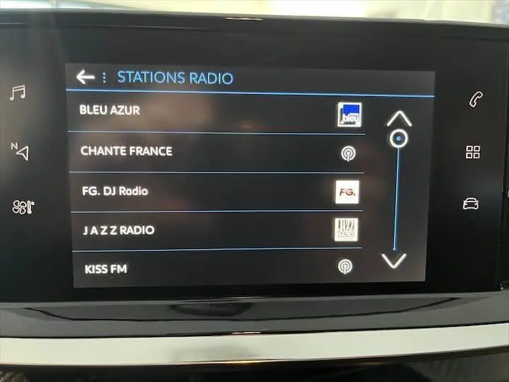 Écran tactile central de la Peugeot 208 2022 affichant la liste des stations radio avec interface moderne noire.