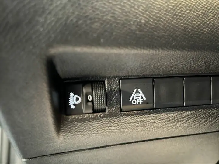 Gros plan sur les commandes d'assistance à la conduite dans l'habitacle d'une Peugeot 208 gris Artense 2022.