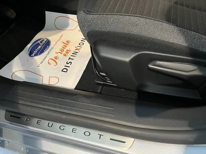 Gros plan sur la marche d'entrée côté conducteur d'une Peugeot 208 gris Artense avec siège tissu gris noir.