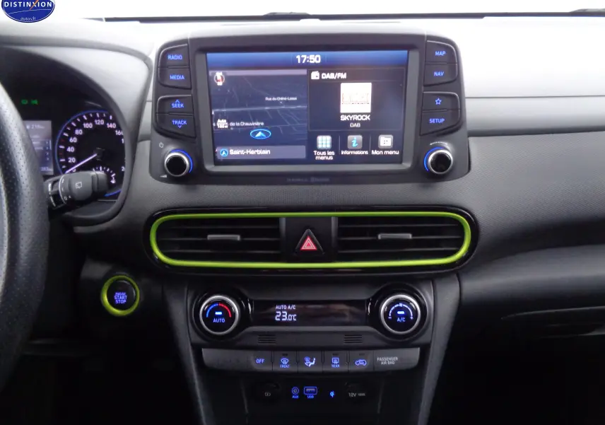 Tableau de bord intérieur du Hyundai Kona 2019 avec écran tactile et accents verts Acid Yellow Metal visibles autour des aérateurs.