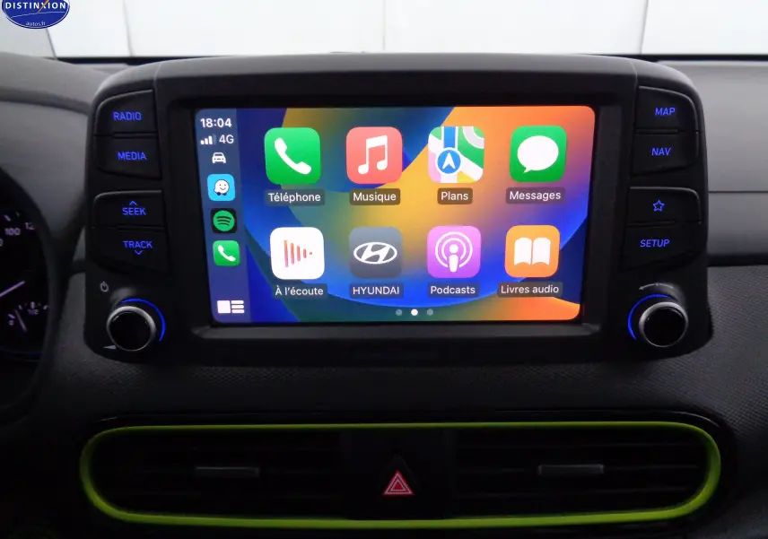 Écran tactile central du Hyundai Kona 2019 affichant Apple CarPlay avec cadre noir et contour vert acidulé.