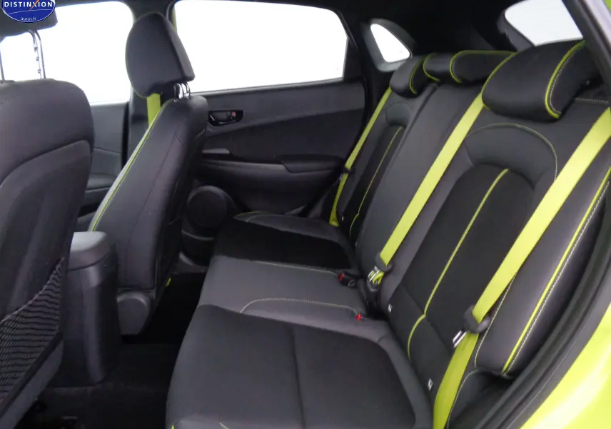 Vue intérieure arrière droite du Hyundai Kona 2019 avec sièges noirs et surpiqûres ainsi que ceintures de sécurité jaune acid yellow metal.