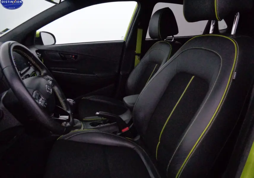 Vue intérieure côté conducteur du Hyundai Kona 1.6 CRDI 115CH Creative avec sièges noirs et surpiqûres jaune acidulé.