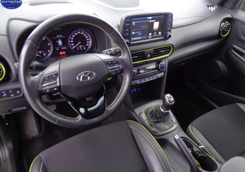 Intérieur du Hyundai Kona 2019 en vue avant, volant cuir noir avec surpiqûres jaunes et console centrale avec écran tactile.