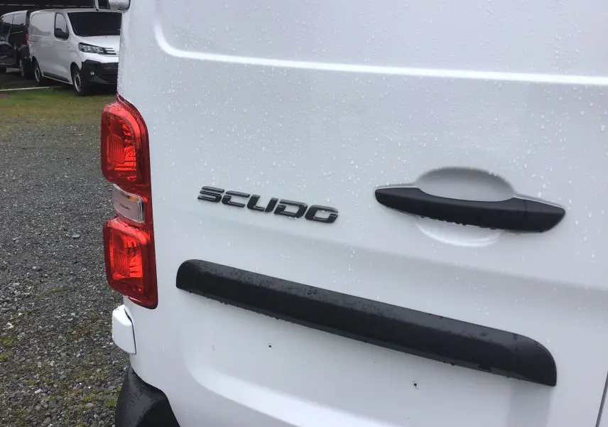 Gros plan sur l'arrière blanc du FIAT Scudo Fourgon 2024, mettant en valeur la poignée noire et le logo "SCUDO".