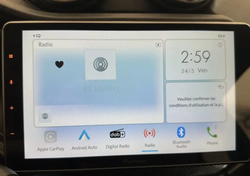 Vue intérieure centrée sur l’écran tactile multimédia Pioneer affichant la radio, dans une Aixam Ambition 0.5 City GTO blanche.