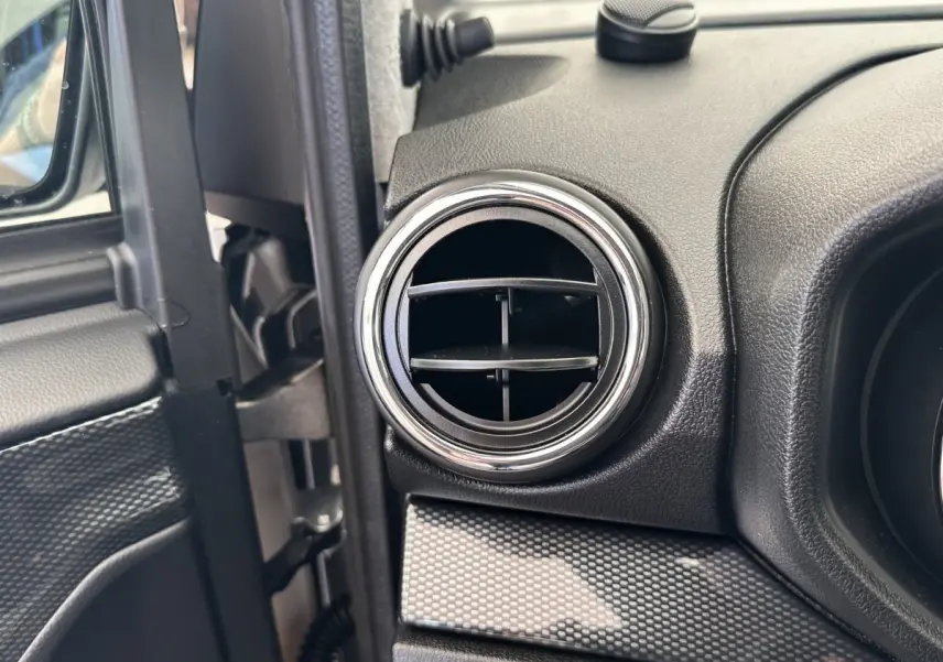 Détail de la sortie d’air ronde côté conducteur de l’habitacle de l’AIXAM AMBITION 0.5 CITY GTO blanc 2026.