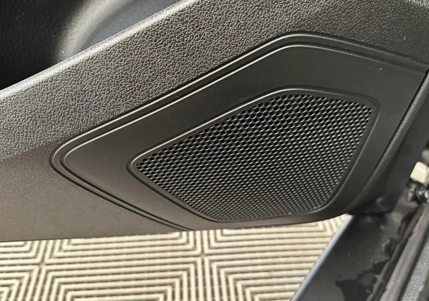 Gros plan sur le haut de la porte côté conducteur de l'AIXAM AMBITION blanc, mettant en valeur le haut-parleur intégré.