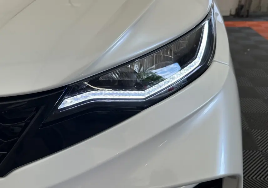 Gros plan sur le phare avant droit blanc de l'AIXAM AMBITION 0.5 CITY GTO 2026 avec éclairage LED distinctif.